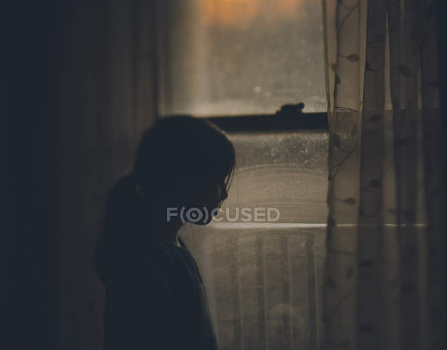 Adolescente chica de pie cerca de ventana - foto de stock