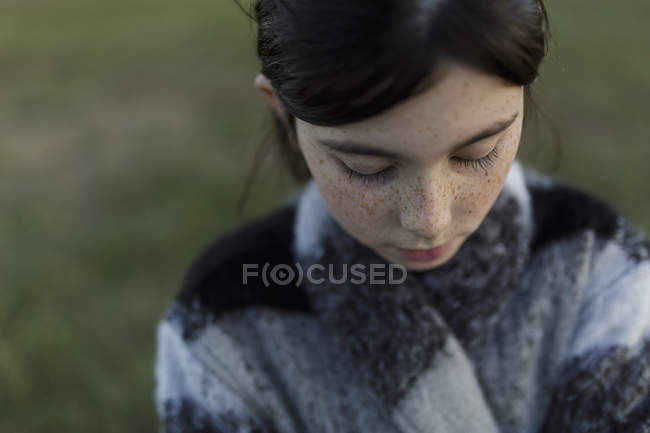 Brunette girl with freckles looking down — Stock Photo