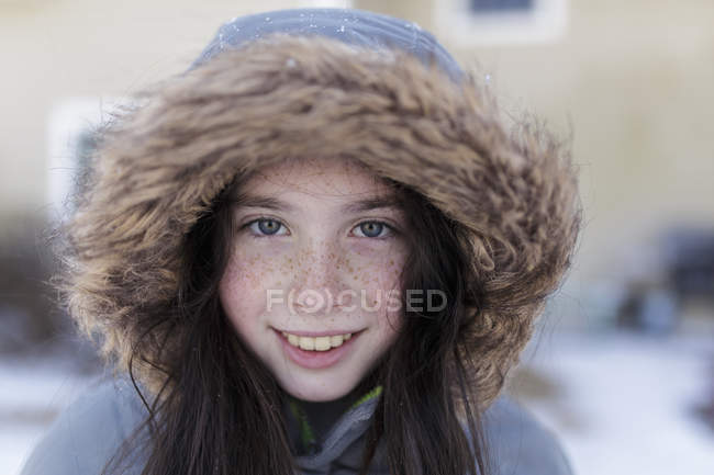 Chica sonriente en chaqueta de invierno con capucha - foto de stock