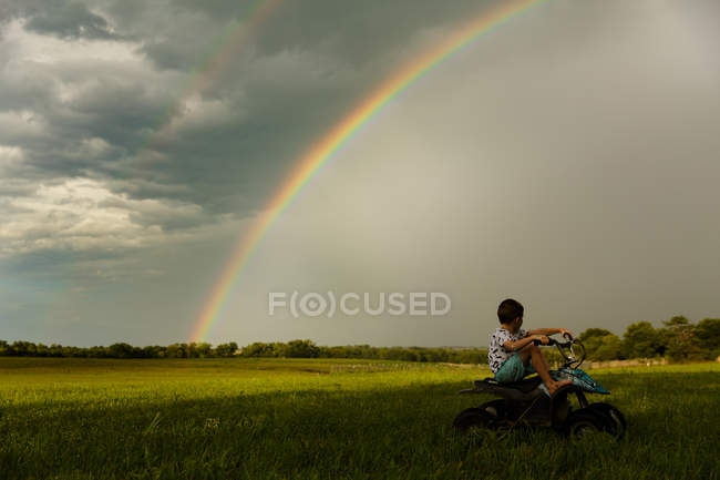 Милый маленький мальчик, сидящий на четырехколесном цикле — стоковое фото
