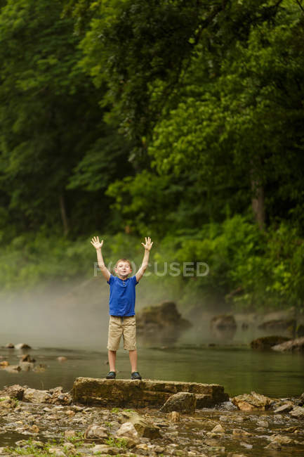 Cute boy with raised hands — Stock Photo