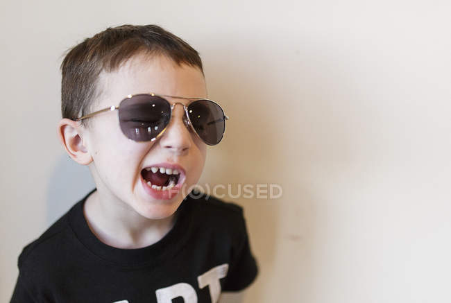 Mignon garçon dans lunettes de soleil rire — Photo de stock