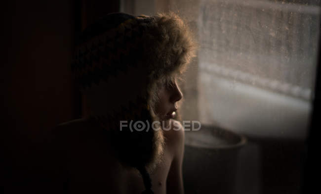 Задумливий хлопчик дивиться на вікно — стокове фото
