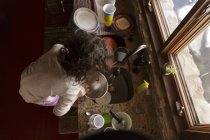 Girl washing dishes — Stock Photo