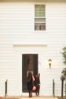 Girls at front door ringing doorbell — Stock Photo