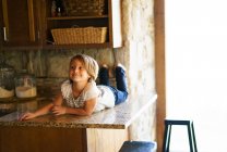 Giovane ragazza sul bancone della cucina . — Foto stock