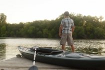 Хлопчик з каяком і веслою біля озера — стокове фото