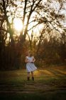 Kleines Mädchen im Kleid posiert im Wald — Stockfoto