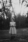 Chica sincera posando en vestido y botas en el bosque - foto de stock