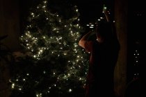 Junge schmückt Weihnachtsbaum — Stockfoto