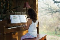 Ragazza che suona il pianoforte a casa — Foto stock