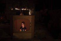 Girl inside funny cardboard tv set — Stock Photo