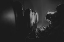 Хлопчик використовує цифровий пристрій у літаку — стокове фото