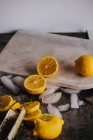 Сочные лимоны и лед на столе — стоковое фото