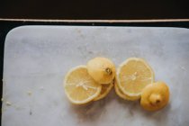 Вид зверху на шматочки лимона на обробній дошці з мармуру — стокове фото