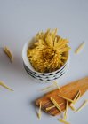 Diretamente acima da vista da cabeça de flor amarela na pilha de tigelas de chá — Fotografia de Stock
