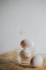 Huevos sin procesar en un recipiente de vidrio sobre papel de hornear - foto de stock