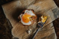 Panier d'œufs déchiré sur papier cuisson avec fourchette — Photo de stock