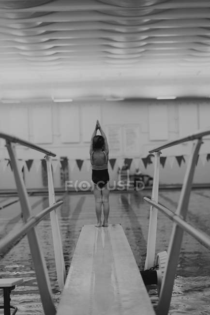 Girl standing at end of diving board — Stock Photo