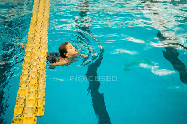 Jeune enfant nageant dans la piscine — Photo de stock