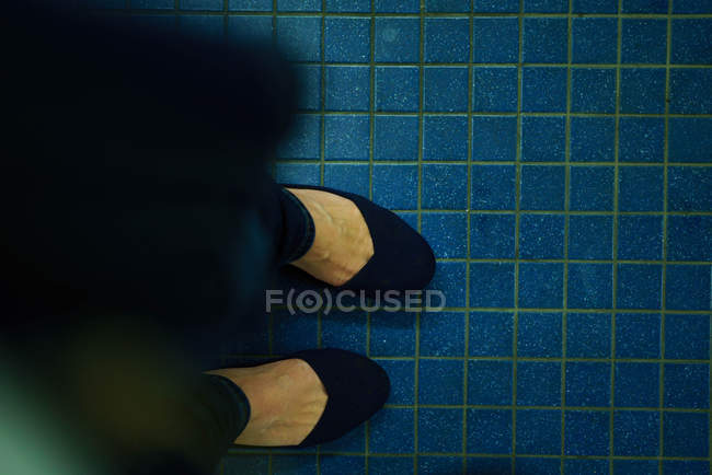 Mujer de pie sobre el azulejo - foto de stock