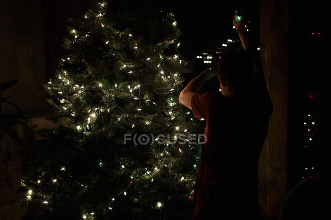 Boy decorating christmas tree — Stock Photo
