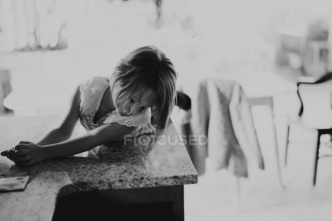 Girl sitting on the kitchen table — Stock Photo