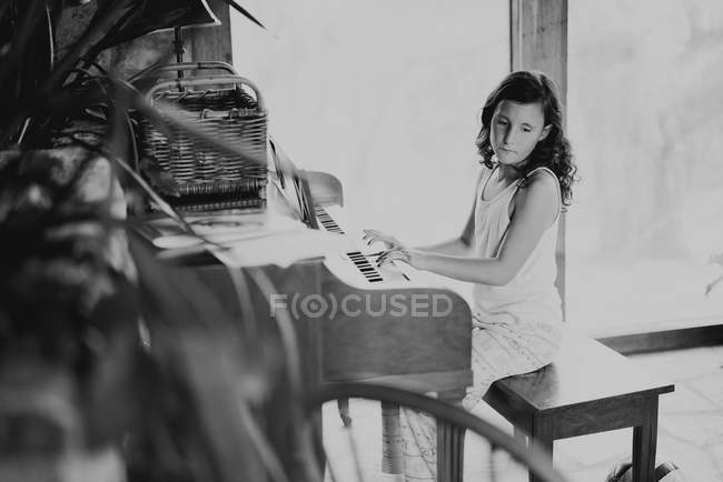 Симпатичная девушка играет на фортепиано — стоковое фото