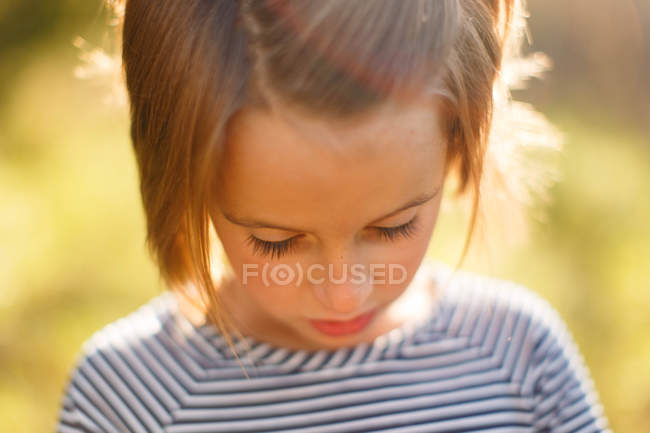 Trauriges kleines Mädchen, das nach unten schaut — Stockfoto