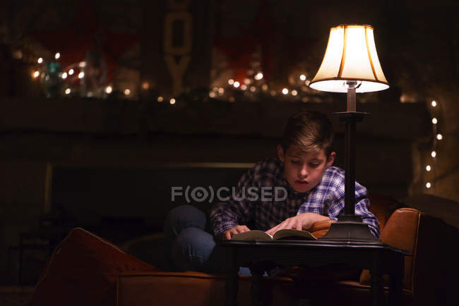 Хлопчик читає книгу на кавовому столі — стокове фото