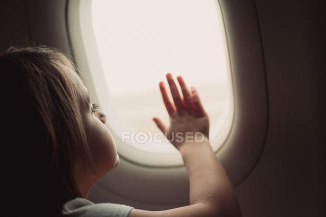 Mädchen blickt auf Flugzeugfenster — Stockfoto