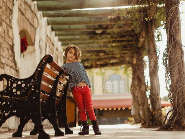 Девушка опирается на скамейку на улице — стоковое фото