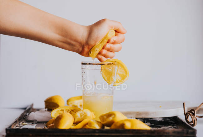 Ernte Faust Saft reife Zitrone im Glas — Stockfoto