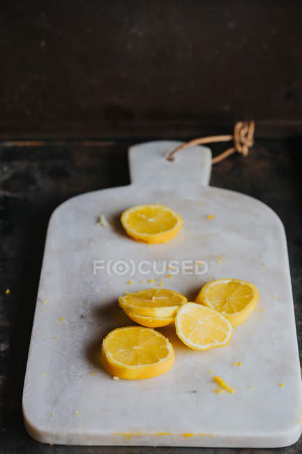 Zitronenscheiben auf Marmorschneidebrett — Stockfoto