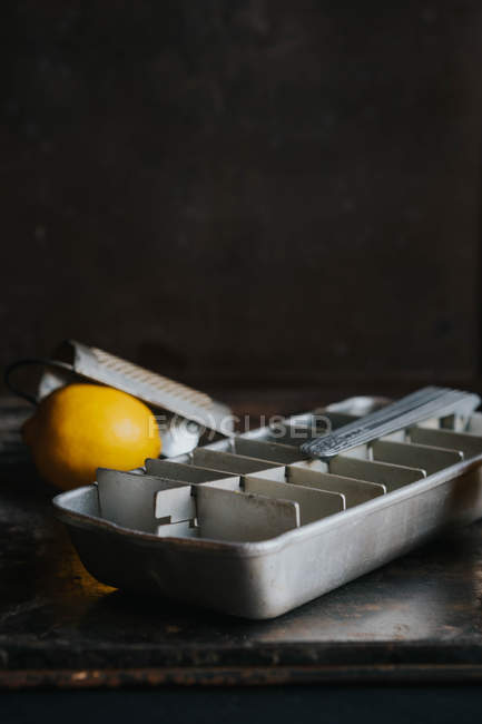 Bodegón de bandeja de hielo con limón y rallador - foto de stock