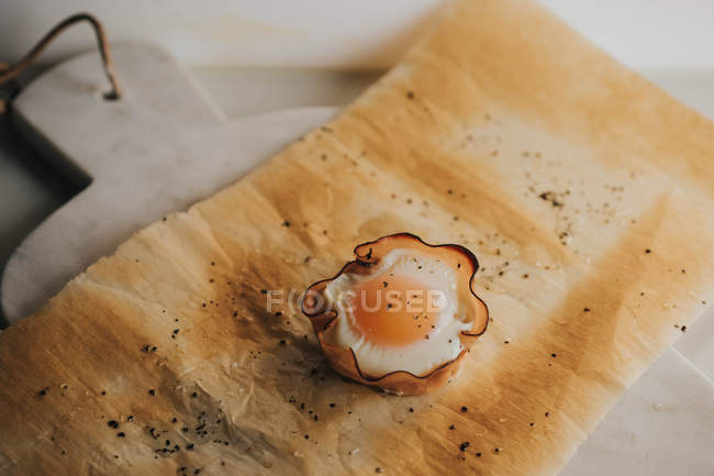 Delicious baked egg basket on baking paper over marble cutting boards — Stock Photo