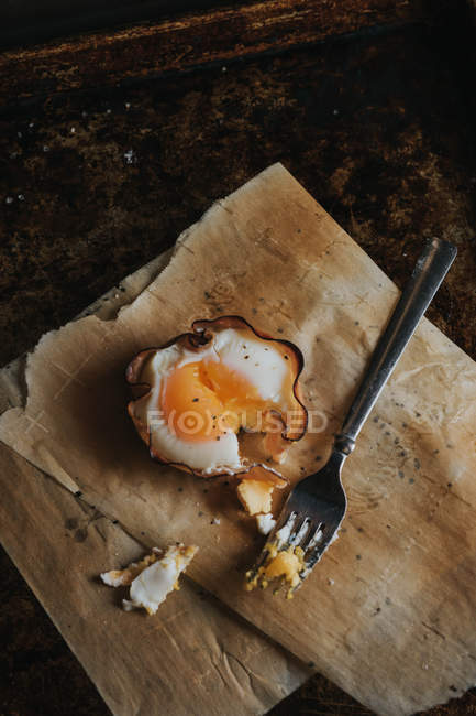 Cesta de huevo desgarrada con tenedor sobre papel de hornear - foto de stock