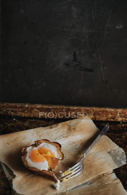 Bodegón de la cesta de huevo al horno con tenedor sobre papel de hornear - foto de stock