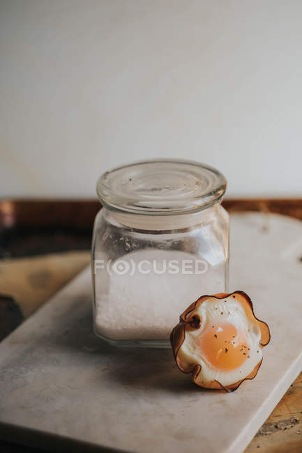 Baked egg basket by jar of sugar on marble board — Stock Photo