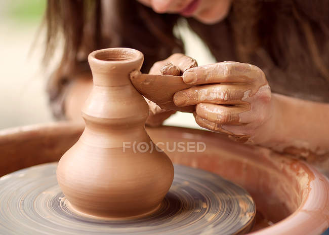 Mani che lavorano sulla ruota della ceramica — Foto stock