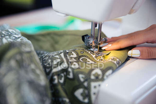 Mano femenina con máquina de coser - foto de stock