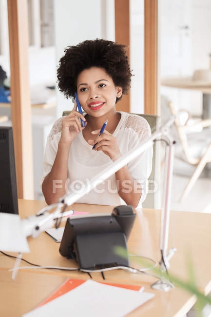 Empresária chamando no smartphone no escritório — Fotografia de Stock