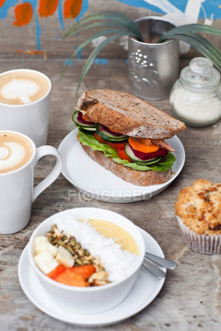 Deux tasses de café chaud Latte Art avec sandwich aux légumes muffins — Photo de stock