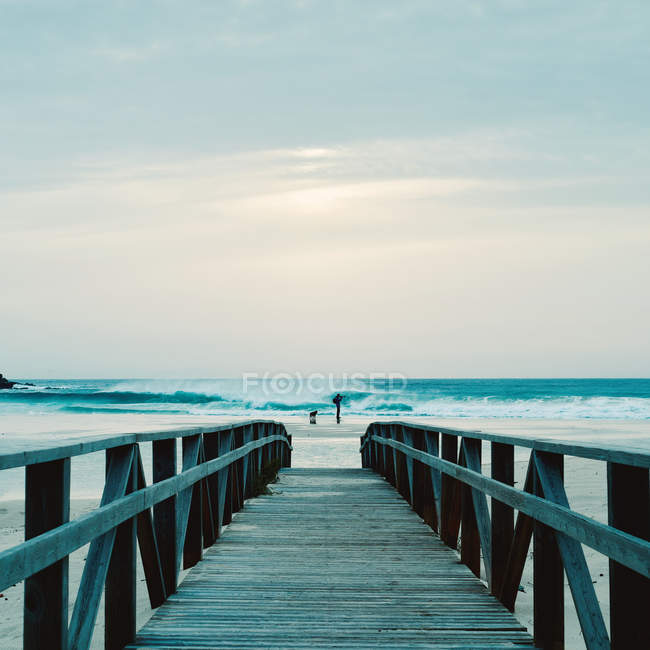 Прогулянка на дошці і людина робить фотографію на пляжі — стокове фото