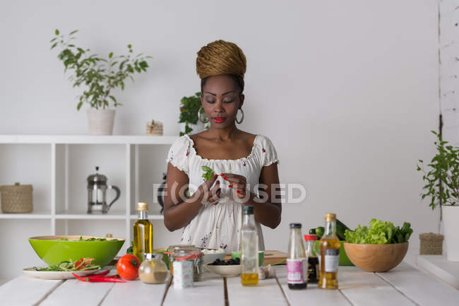 Mujer africana preparando ensalada - foto de stock