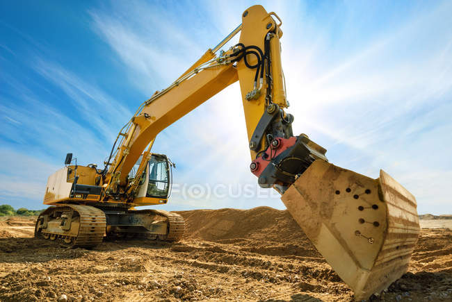 Big excavator in front of the blue sky — Stock Photo