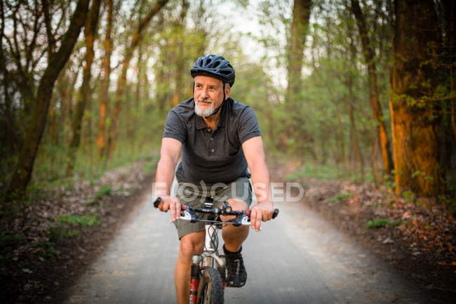 Старший чоловік на своєму гірському велосипеді на відкритому повітрі — стокове фото