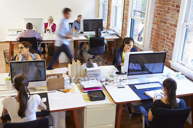 Зайнятий дизайн офіс з працівниками на столах — стокове фото