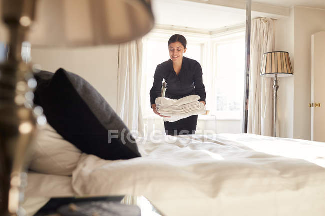 Zimmermädchen legt Bettwäsche aufs Bett — Stockfoto