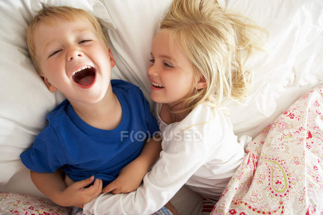 Bruder und Schwester entspannen gemeinsam im Bett — Stockfoto